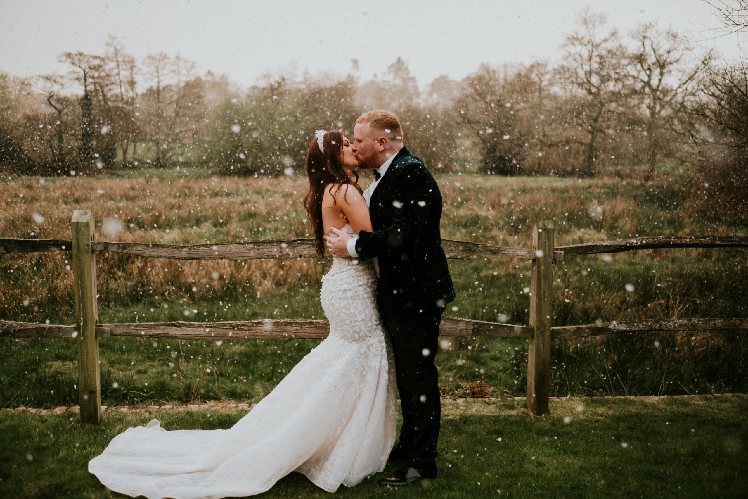 couple share a kiss in the snow at Millbridge Court March wedding